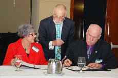 Ann Edge, Professor Phillip Green and Professor Lawrence Rose sign the partnership at the AMINZ conference.