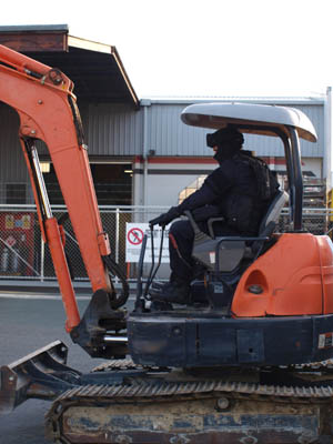 Police use digger to gain entry into Red Devils HQ.