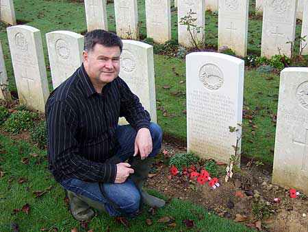 Professor Glyn Harper at the Caterpillar Valley Cemetery in the Somme province of France,  kneeling next to the original grave of the soldier who now rests in the Tomb of the Unknown  Warrior in Wellington.