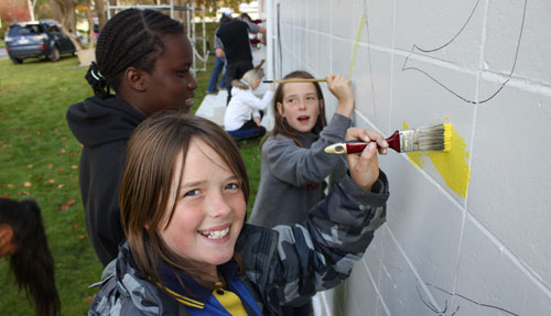 From left, Clench Enoka, Billie Jessup and Shania Jessup make a start on a mural that will cover their clubhouse, the Treadwell Street Hall.
