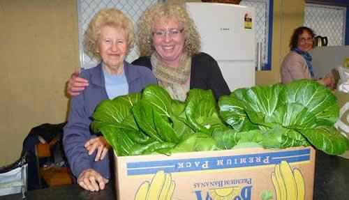 Betty Hodgins, left and Tina Togher at Hutt City Council's foodbank gratefully take the first organic produce from the raised vegetable bed built by council staff.
