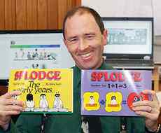 Steve Scott with copies of two books of his cartoons and  examples of his comic strips on the screens behind him.